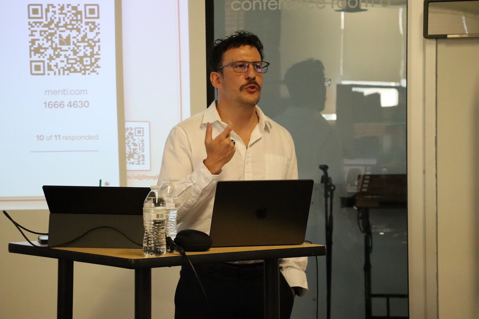 David speaking on AI in healthcare with a Mentimeter slide behind him